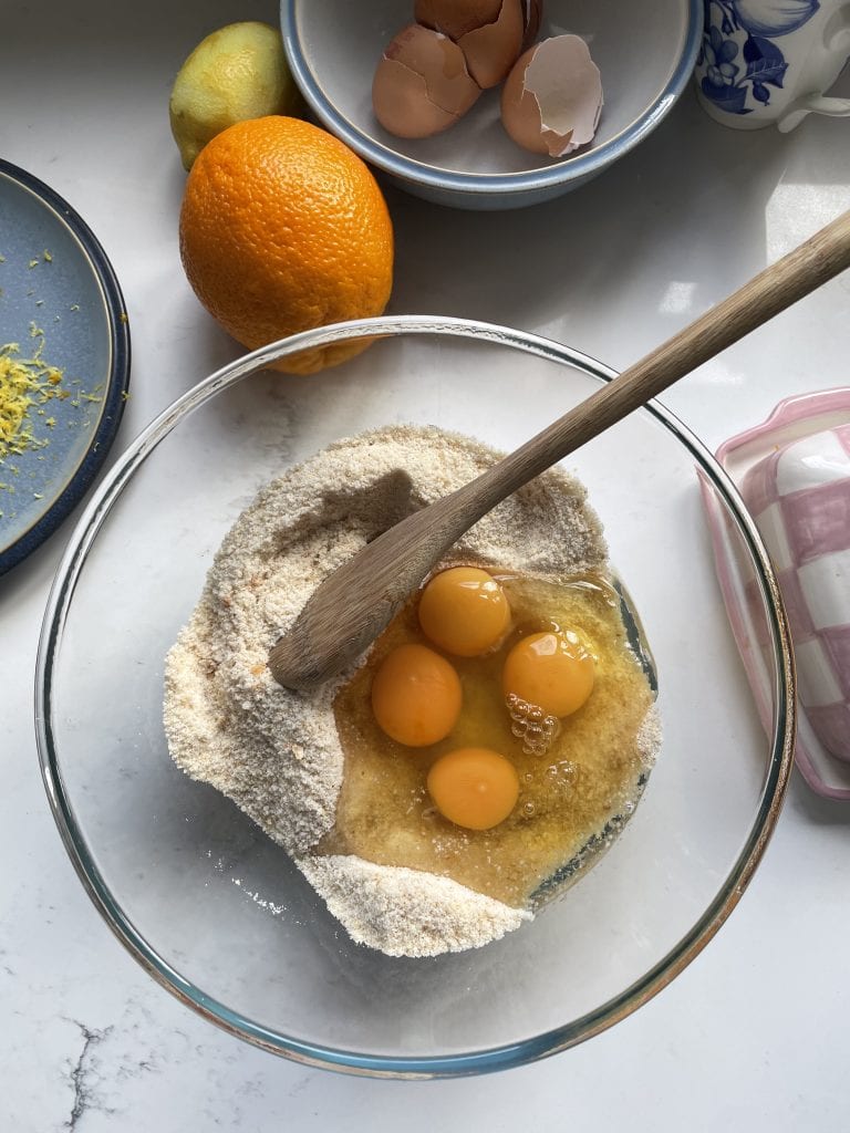 Adding eggs in the glass mixing bowl