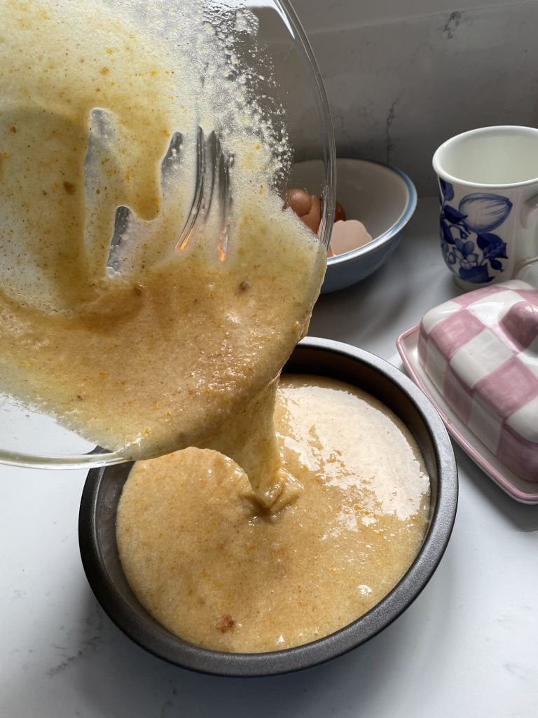 Pouring cake mix into lined cake tin